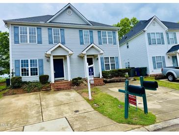 Charming townhome featuring a well-maintained lawn and a symmetrical facade with blue shutters at , Raleigh, NC 27604