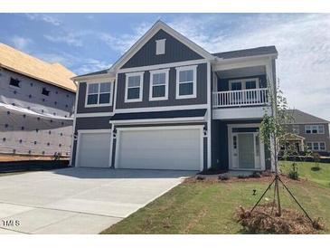 New construction home with a two-car garage, covered balcony, and blue horizontal siding at 245 N Maple Walk Dr # 219, Garner, NC 27529
