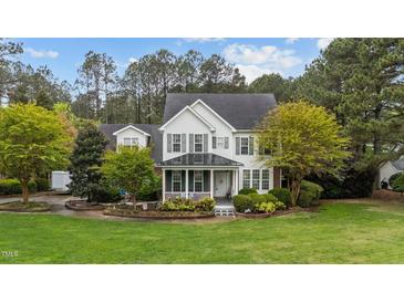 Charming two-story home featuring a well-manicured lawn and inviting front porch at 402 Green Turret Dr, Rolesville, NC 27571