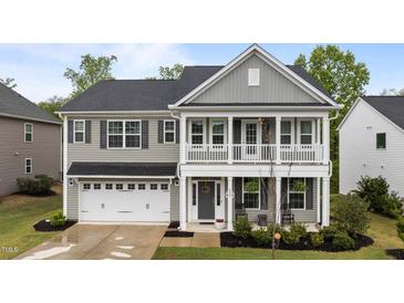 Charming two-story home with a welcoming front porch and a two-car garage, showcasing classic architectural details at 4803 Stony Falls Way, Knightdale, NC 27545