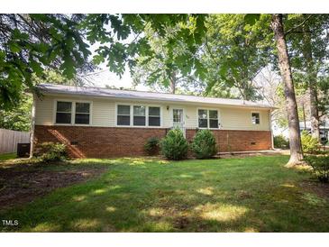 Ranch style home with brick and vinyl siding, manicured lawn and mature trees offering curb appeal at 505 E Graham St, Mebane, NC 27302
