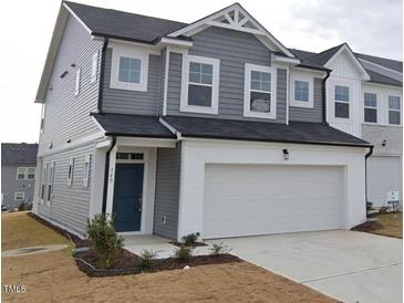 Charming two-story home with a two-car garage and a modern design, featuring gray siding and a welcoming entrance at 540 Eversden Dr, Zebulon, NC 27597