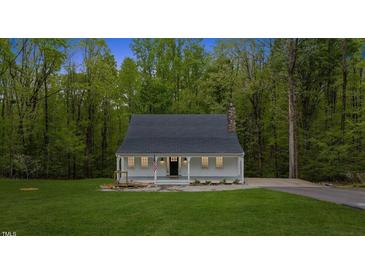 Charming home featuring a covered front porch, manicured lawn, and mature trees at 5541 Old Still Rd, Wake Forest, NC 27587
