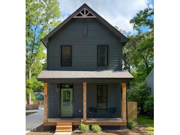 Charming two-story home featuring a quaint front porch, dark gray siding and wood post supports at 612 E Ellerbee St, Durham, NC 27704
