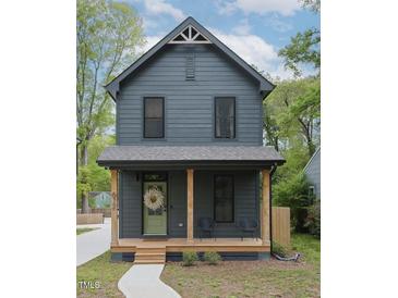 Charming two-story home with a welcoming front porch, natural wood columns, and tasteful landscaping at 612 E Ellerbee St, Durham, NC 27704