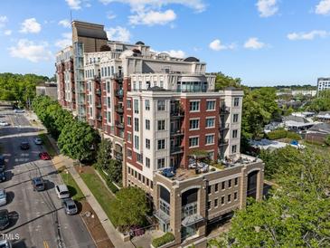 Beautiful multi-story condo building boasting brick and white accents, lush landscaping, and rooftop terraces at 618 N Boylan Ave # 304, Raleigh, NC 27603