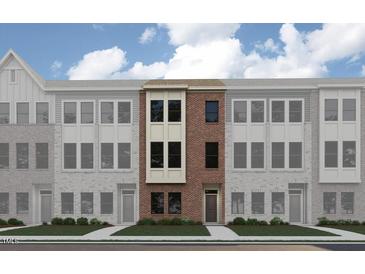 Modern townhouse exterior features a brick facade, symmetrically placed windows, and a well-manicured lawn at 668 Bandon Aly, Cary, NC 27513