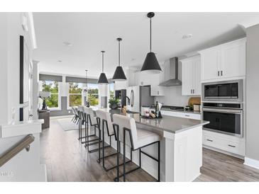 Bright, open kitchen with a large island, modern appliances, and stylish pendant lighting at 670 Bandon Aly, Cary, NC 27513