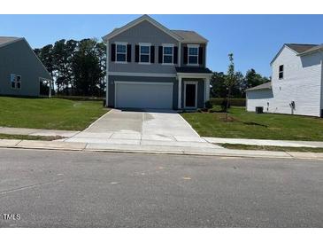 Charming two-story home with gray siding, a well-manicured lawn, and an attached two-car garage at 817 Kenyon Springs Dr, Zebulon, NC 27597