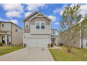 Charming two-story home with a two car garage, neutral siding, and well-manicured lawn at 82 White Ash Dr, Clayton, NC 27527