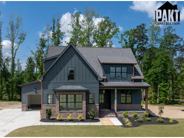 Two-story home showcases a mixed material facade, complemented by a lush lawn and professional landscaping at 8620 Dukes Lake Rd, Zebulon, NC 27597