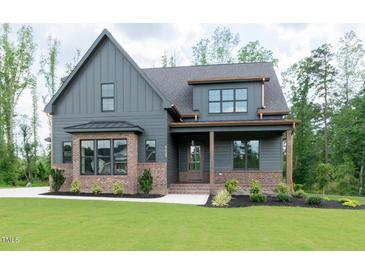 Charming two-story home featuring a mix of siding and brick with an inviting front porch and lush landscaping at 8620 Dukes Lake Rd, Zebulon, NC 27597