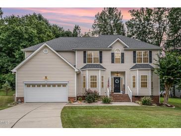 Charming two-story home with neutral siding, a well-manicured lawn and an attached two-car garage at 106 Teak Cir, Garner, NC 27529