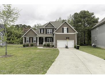 Inviting two-story home with a well-manicured lawn, attached garage, and a classic brown exterior at 1108 Agio Ct, Zebulon, NC 27597