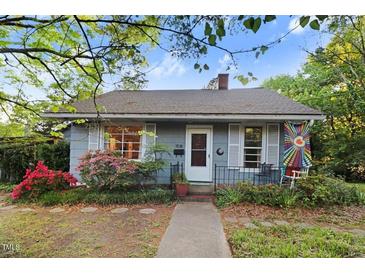 Charming single-story home with a cozy front porch, flowering bushes, and sidewalk leading to the front door at 1518 Echo Rd, Durham, NC 27707