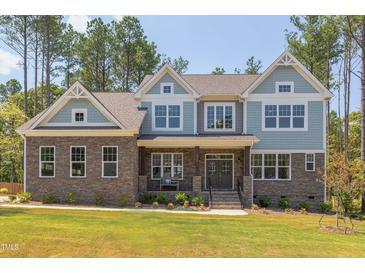 Charming two-story home showcasing a stone facade and varied siding for enhanced curb appeal at 205 Riverine Dr, Pittsboro, NC 27312
