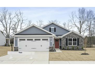Charming home with stone accents, red front door, and a two-car garage at 21 Artesa Ct, Fuquay Varina, NC 27526