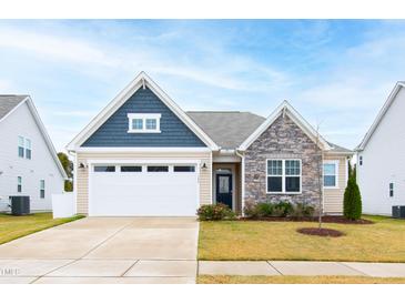 Charming single-Gathering home featuring stone accents, a two-car garage, and a well-manicured lawn at 124 Alta Crest Ln, Garner, NC 27529