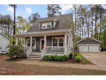 Charming home boasts a cozy porch, white railings, and a vibrant red door at 2007 Watson Rd, Durham, NC 27704