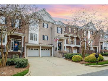 Charming brick townhomes feature attached garages, mature landscaping and a welcoming curb appeal at 214 Lions Gate Dr, Cary, NC 27518