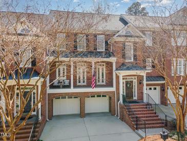 Charming three-story townhome with brick facade, attached garages, and front balcony at 222 Lions Gate Dr, Cary, NC 27518