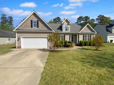 Inviting traditional home boasting manicured lawn, attached garage, and neutral siding under a sunny sky at 30 Alvis Ct, Fuquay Varina, NC 27526