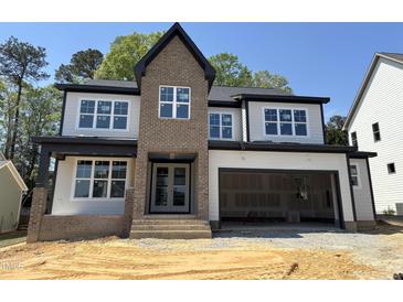 Two-story home with large windows, brick accents, and an attached two-car garage in a well-lit area at 3412 Amelia Grace Dr # 43, Fuquay Varina, NC 27526