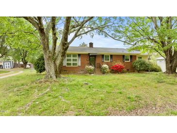 Charming brick home with mature trees, flowering shrubs, and a welcoming front entrance at 428 Mitchell Ave, Franklinton, NC 27525