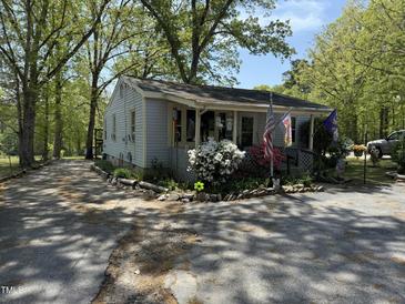 Charming single-story home surrounded by mature trees and colorful landscaping at 5138 Nc 56, Franklinton, NC 27525