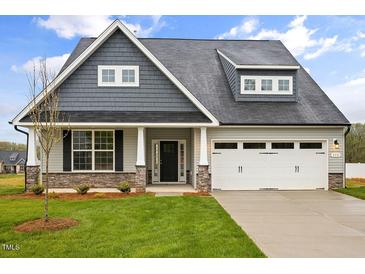 Charming home with a well-manicured lawn, stone accents, and a two-car garage at 1073 Fairhaven Dr # 52, Mebane, NC 27302