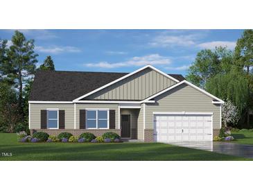 Charming single-story home featuring a two-car garage, a well-manicured lawn, and an inviting facade at 1208 Pavo Path, Wendell, NC 27591