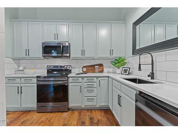 Well-lit kitchen with updated appliances, sleek countertops, and ample cabinet space at 1535 Caraleigh Mills Ct # 104, Raleigh, NC 27603