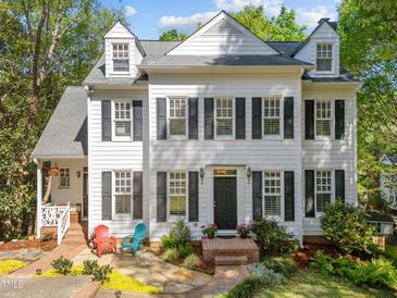 Charming two-story home featuring white siding, black shutters, and a well-manicured front yard and mature trees at 2520 Ashley Ct, Raleigh, NC 27607