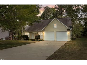 Inviting home showcasing a well-manicured lawn, a two-car garage, and classic exterior finishes at 378 E Raleigh Ave, Liberty, NC 27298