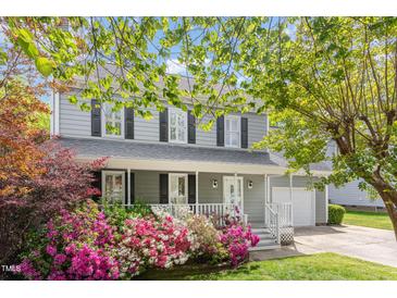 Charming gray home with a welcoming front porch and vibrant pink and white azaleas in the front yard at 5033 Knightsbridge Way, Raleigh, NC 27604