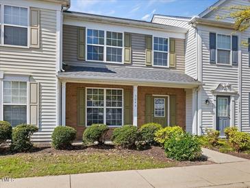 Charming townhouse featuring a brick facade, green shutters, and well-maintained landscaping at 5044 Brooke Lauren Ln, Raleigh, NC 27616