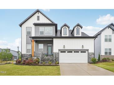 Beautiful two-story home featuring a two-car garage, stone accents, and a welcoming front porch at 5616 Horsewalk Cir, Raleigh, NC 27606