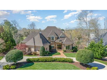 Stately brick home featuring a meticulously landscaped front yard and a grand entrance at 595 Legacy Falls N Dr, Chapel Hill, NC 27517