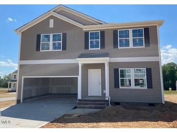 Two-story home with gray siding, black shutters, a large front-facing garage, and a light-colored front door at 84 Grove Township Way, Angier, NC 27501