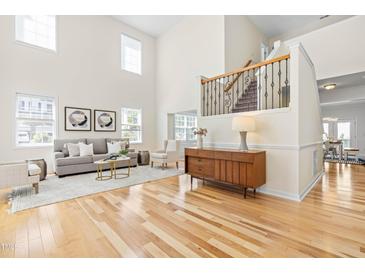 Bright living room with hardwood floors, neutral decor, and a soaring two-story ceiling at 101 Vista Brooke Dr, Morrisville, NC 27560