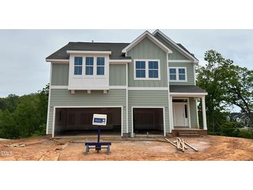 Two-story home features a two-car garage, light green siding and white trim at 107 Berry Mill Ln # 134, Raleigh, NC 27603