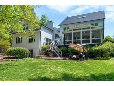 Expansive backyard featuring a screened in porch, tiered patio, and lush lawn at 111 Finnway Ln, Cary, NC 27519