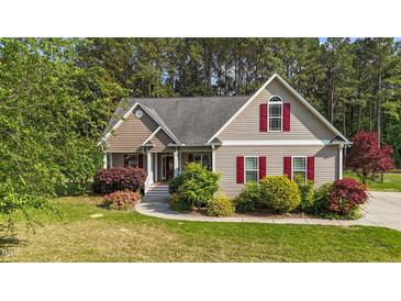 Charming home boasts a well-maintained lawn, mature trees, and vibrant landscaping at 1141 Contender Dr, Clayton, NC 27520