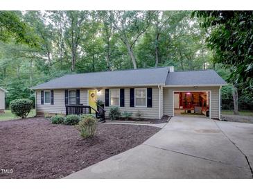 Charming ranch home with a yellow front door, black shutters, and an attached one-car garage at 1536 Dirkson Ct, Cary, NC 27511