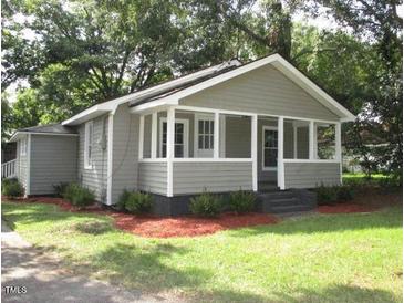 Charming one-story home featuring a covered front porch and mature landscaping at 176 Fletcher Ave, Fuquay Varina, NC 27526