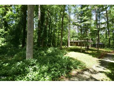 Secluded single story brick home with mature trees and landscaping on a wooded lot at 208 Clark Lake Rd, Durham, NC 27707