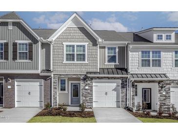 Charming townhouse with a mix of stone, brick, and shingle exterior, complemented by a white garage door at 2126 Willow Gln Dr, Graham, NC 27253