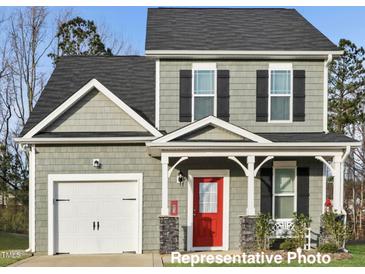 Charming two-story home with a red door, a white garage door and a manicured lawn at 322 Bluejay St, Clayton, NC 27520