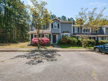 Charming townhome featuring a well-maintained front yard with beautiful flowering bushes and large mature trees at 519 Touchstone Dr, Durham, NC 27713