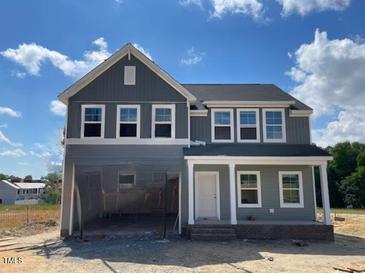 Charming two-story home featuring gray siding, white trim, and an inviting front porch at 54 Grove Township Way, Angier, NC 27501